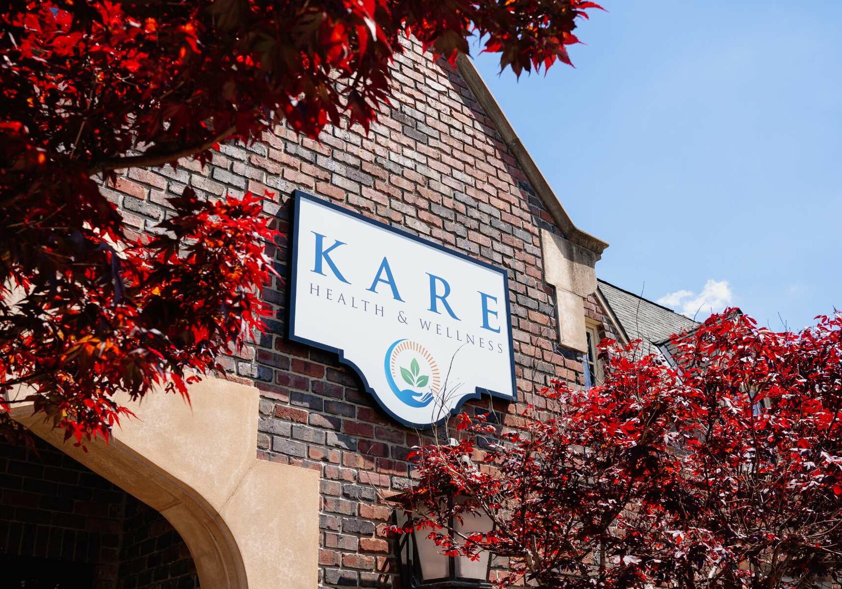 The outside sign for Kare Health and Wellness on their brick building in Springfield Missouri