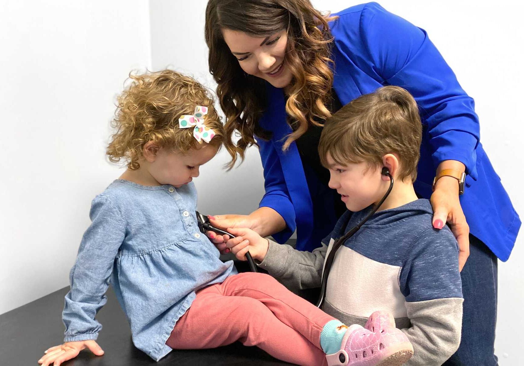 Nurse practitioner at Kare Health and Wellness helping a child during a pediatric visit.